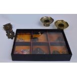 A small cabinet of unusual Tibetan artifacts including a belt buckle, a plaque, two small paintings,