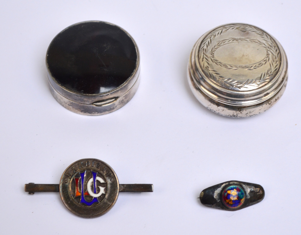 A George V hallmarked silver circular pill box with tortoiseshell set to the hinged lid,