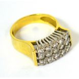An 18ct gold dress ring with a platform design set with fifteen diamonds and eight smaller diamonds,