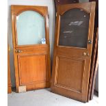 Two oak doors with arched opaque glass top over lower panel with some original door furniture,