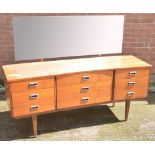 A retro teak nine drawer mirror back sideboard on tapering legs, width 155cm.