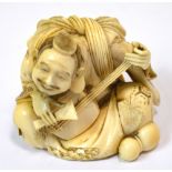 A Japanese Meiji period carved ivory okimono modelled as a seated musician with exaggerated