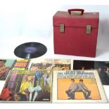 A red record case containing a quantity of vinyl to include The Rolling Stones, Buddy Holly,