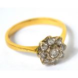 A yellow metal daisy cluster ring set with nine small diamonds, the central diamond approx 1/8ct,