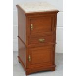 A mid 20th century mahogany and inlaid bedside cabinet, the marble top above cupboard door,