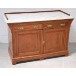 An Edwardian walnut washstand, the white marble top above two frieze drawers,