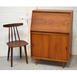 A stick back chair and a retro bureau with drop-down desktop above two sliding doors,