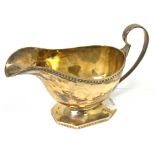 A George V hallmarked silver sauce boat with bead decorated rim,