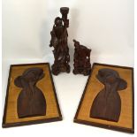 A pair of Indonesian wooden portraits on hessian (framed),