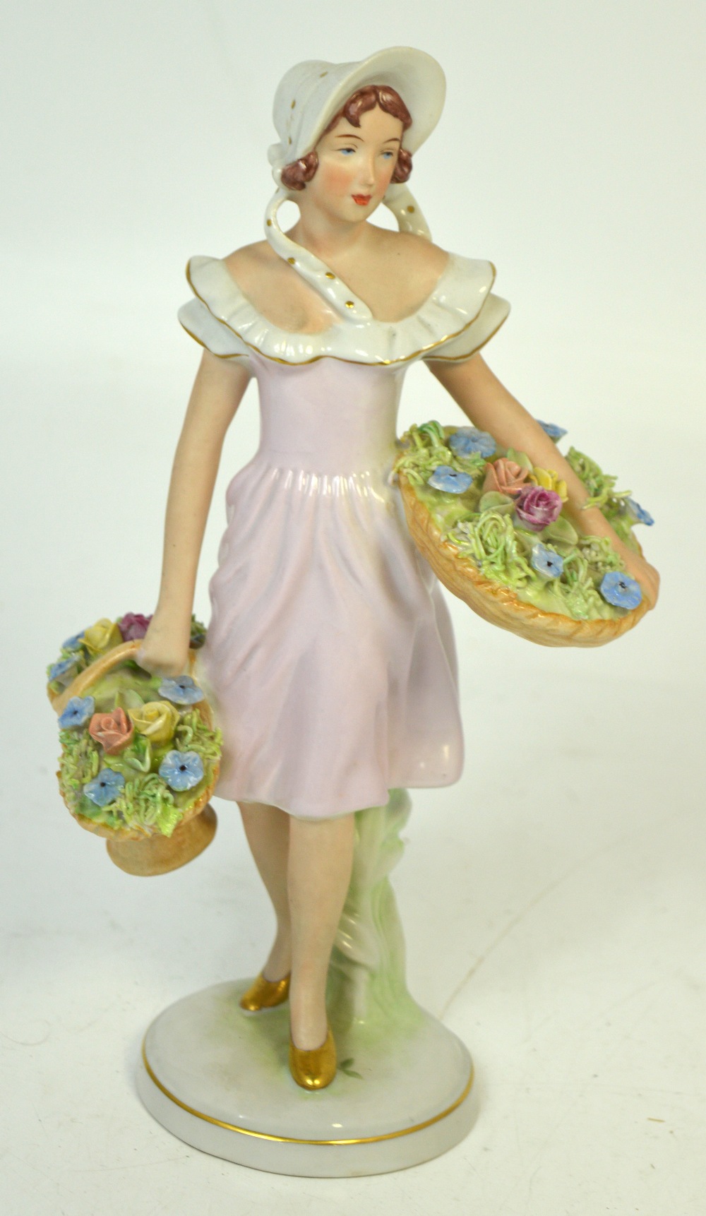 A Royal Dux figurine of a flower seller, pink triangle mark to the base,