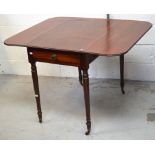 A late George III mahogany Pembroke table raised on turned tapering legs to brass caps and castors,