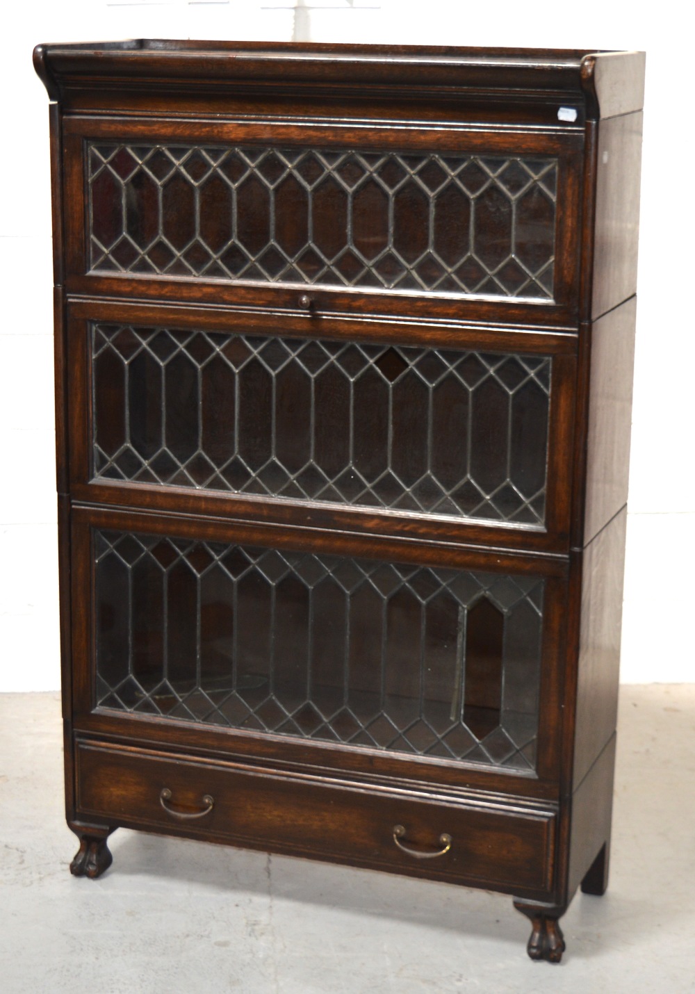 An early 20th century Globe-Wernicke style oak three tier bookcase with astragal glazed lift-up