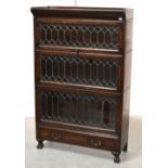 An early 20th century Globe-Wernicke style oak three tier bookcase with astragal glazed lift-up