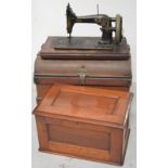 A Victorian cased table sewing machine enclosed within a small metal trunk.