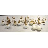 Three five arm brass light fittings with opaque glass spherical shades,