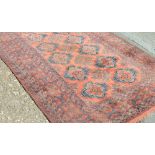 An antique Persian Kirman rug with central medallion and floral design on a muted green main field,