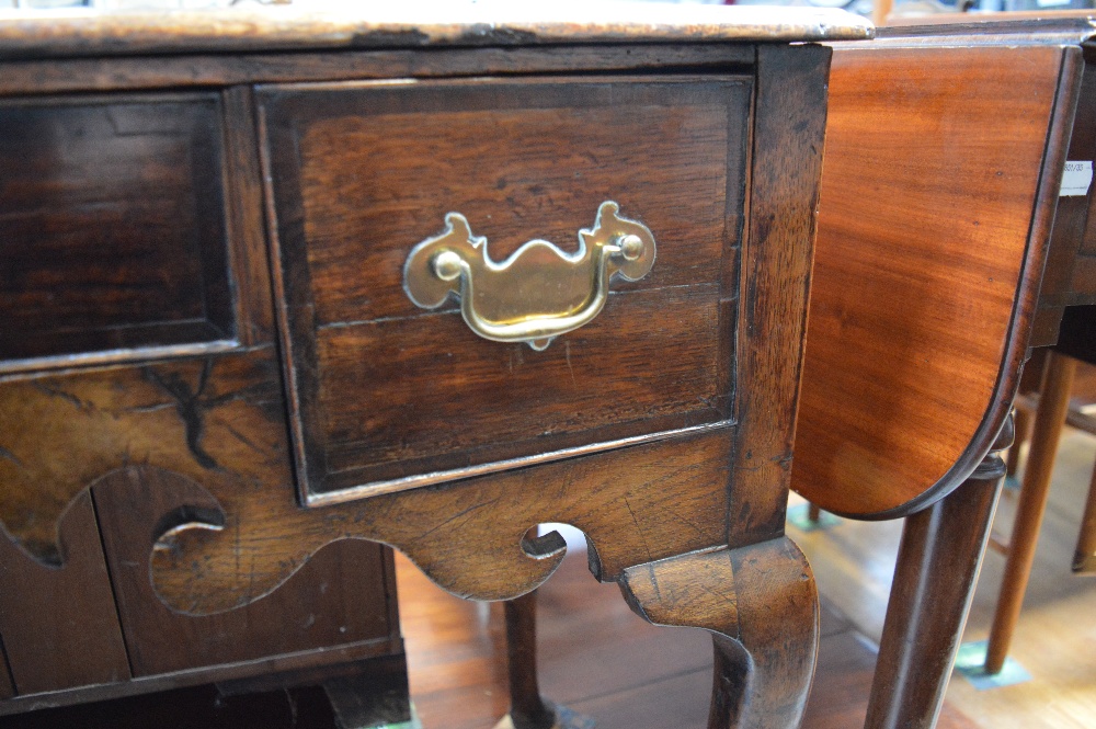 An 18th century oak lowboy with three drawers and shaped apron on pad feet, width 83cm. - Image 2 of 4