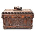 A heavily carved oak coffer with lion mask heads and floral decoration to the top,