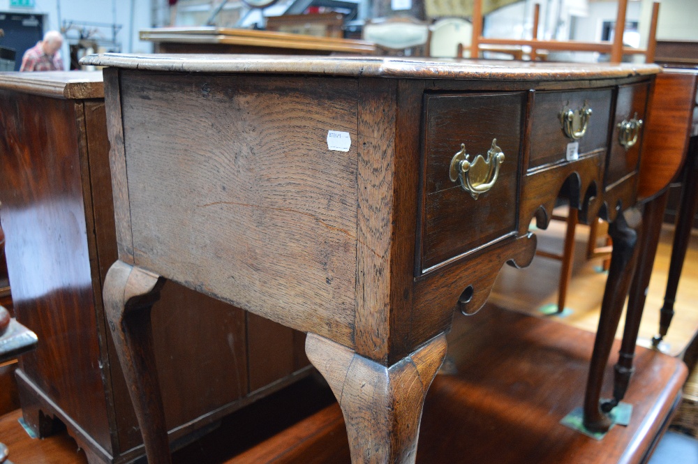 An 18th century oak lowboy with three drawers and shaped apron on pad feet, width 83cm. - Image 4 of 4