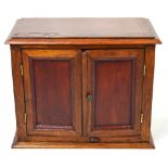 A miniature two door cabinet on plinth base, width 37cm.