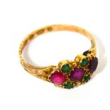 A ladies' 12ct gold dress ring set with three central red stones and four small green stones,