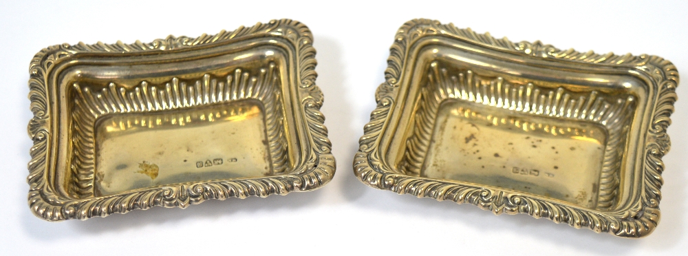 A pair of Edwardian hallmarked silver pin dishes of rounded rectangular form with floral scrolling