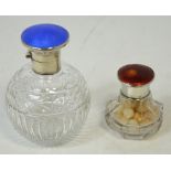 A cut glass ovoid perfume bottle with silver and blue guilloché top and a cut glass bottle with a