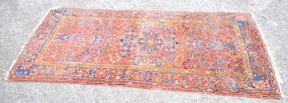 An antique Persian Hamadan rug with all over floral tree and foliage design in multicolour on a