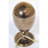 A George III hallmarked silver egg shaped pepper with pierced domed screw cover and spreading