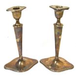A pair of Edwardian loaded hallmarked silver candlesticks,