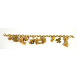 A 9ct gold charm bracelet set with a number of charms including a puppy, sewing machine,