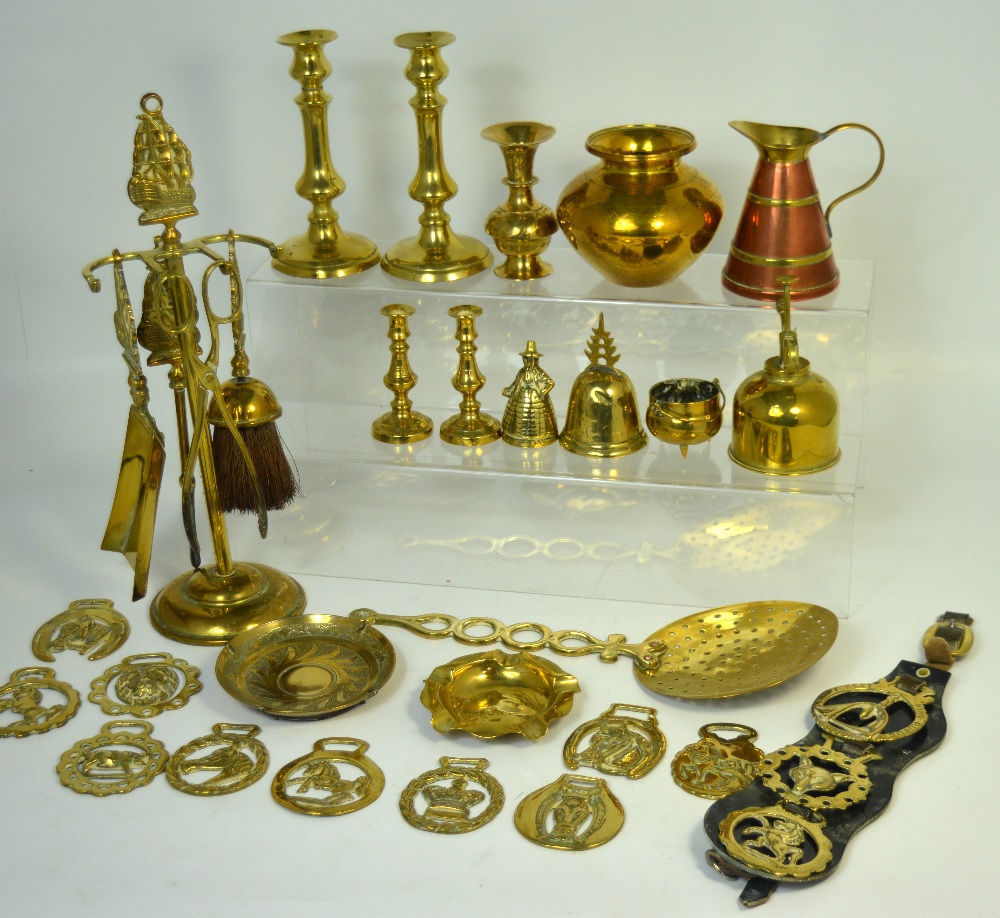 A quantity of brass ware to include a wall plaque, various pots, a companion set, candlesticks,