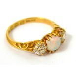 An 18ct yellow gold opal and diamond ring the central opal flanked either side by a diamond,