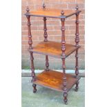 An Edwardian inlaid three tier whatnot on castors.