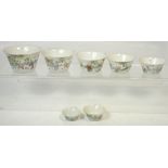 A set of seven c1900 Chinese porcelain stacking bowls, each decorated with figures in a landscape,