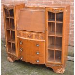 An oak display cabinet/bureau with four central drawers on moulded feet, width 121cm.