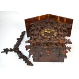 A Black Forrest style carved eight day cuckoo clock, the dial set with Roman numerals,