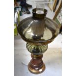 An oil lamp with grey glass shade on a wooden base with armorial decoration,