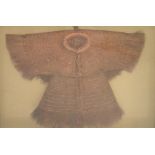 A model of a Chinese 17th century raincoat made of coconut husks, framed and glazed, 40 x 44cm.