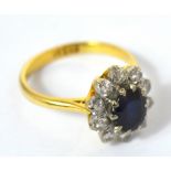 An 18ct gold ring, floral set with a central dark blue sapphire and ten small diamonds, size N,