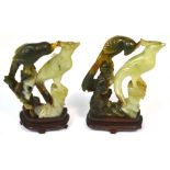 A pair of Chinese jadeite carvings, each modelled as two exotic birds on shaped wooden stands,