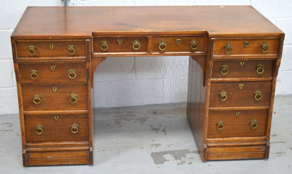 An early 20th century oak kneehole desk, two central drawers over four drawers to either side,