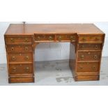 An early 20th century oak kneehole desk, two central drawers over four drawers to either side,