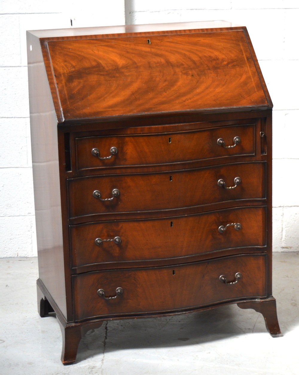 An early 20th century mahogany serpentine front bureau on splayed legs, 100 x 69cm.