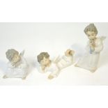 Three Lladró figures of small cherubs, one sleeping with hand on knee,