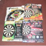 Four boxed dart boards comprising three Winmau examples and one Unicorn example,