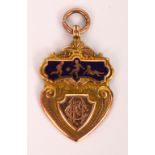 An Edwardian 9ct gold and enamelled footballing medallion of shield form,