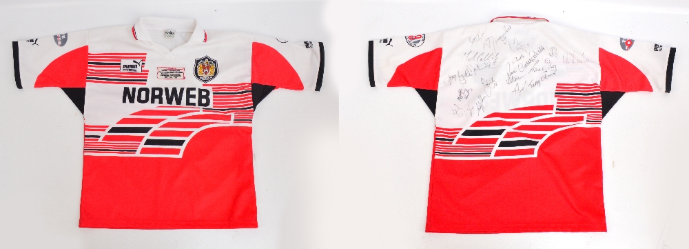 A multi-signed replica Wigan Rugby League shirt, with badges including "WORLD CHAMPIONS,