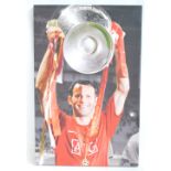 RYAN GIGGS; a large photographic print on canvas, signed by Giggs holding a trophy aloft, 89 x 59cm,