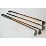 Four early 20th century hickory shafted golf clubs with leather grips including WB Dunnett Special